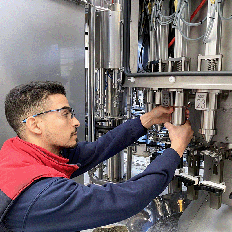 Technician performing adjustment and maintenance on rotary filling components to ensure reliable operation.