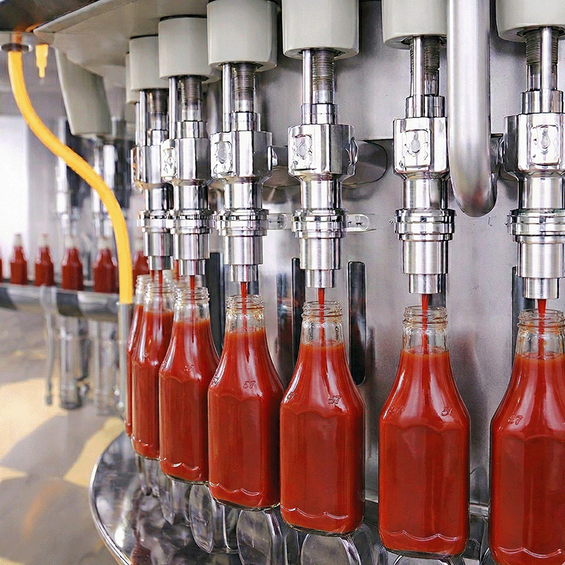 Weight filler filling PET bottles of ketchup.